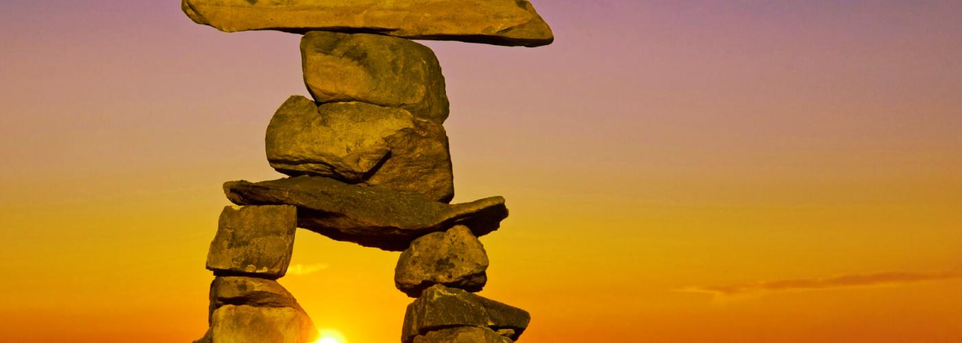 Inuksuk with setting sun in background